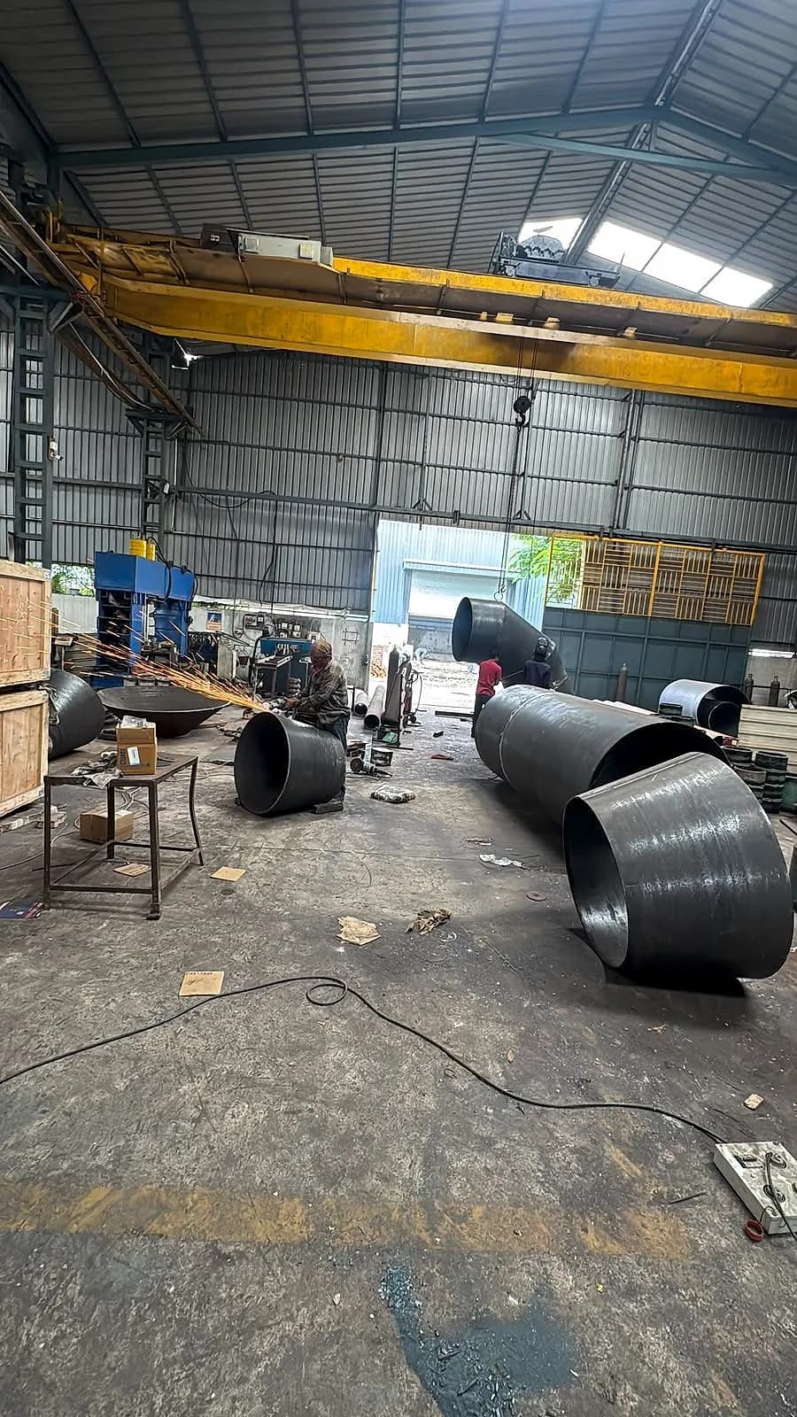 The fabrication bay with an overhead crane and large reducers on the floor